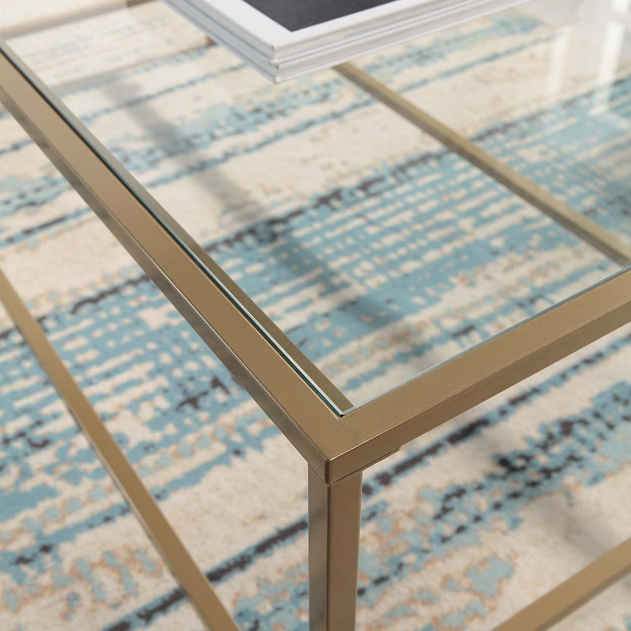 Mesa de centro rectangular, con vidrio temperado y marco de metal dorado. 111cms x 52.7cms x 45.4cms