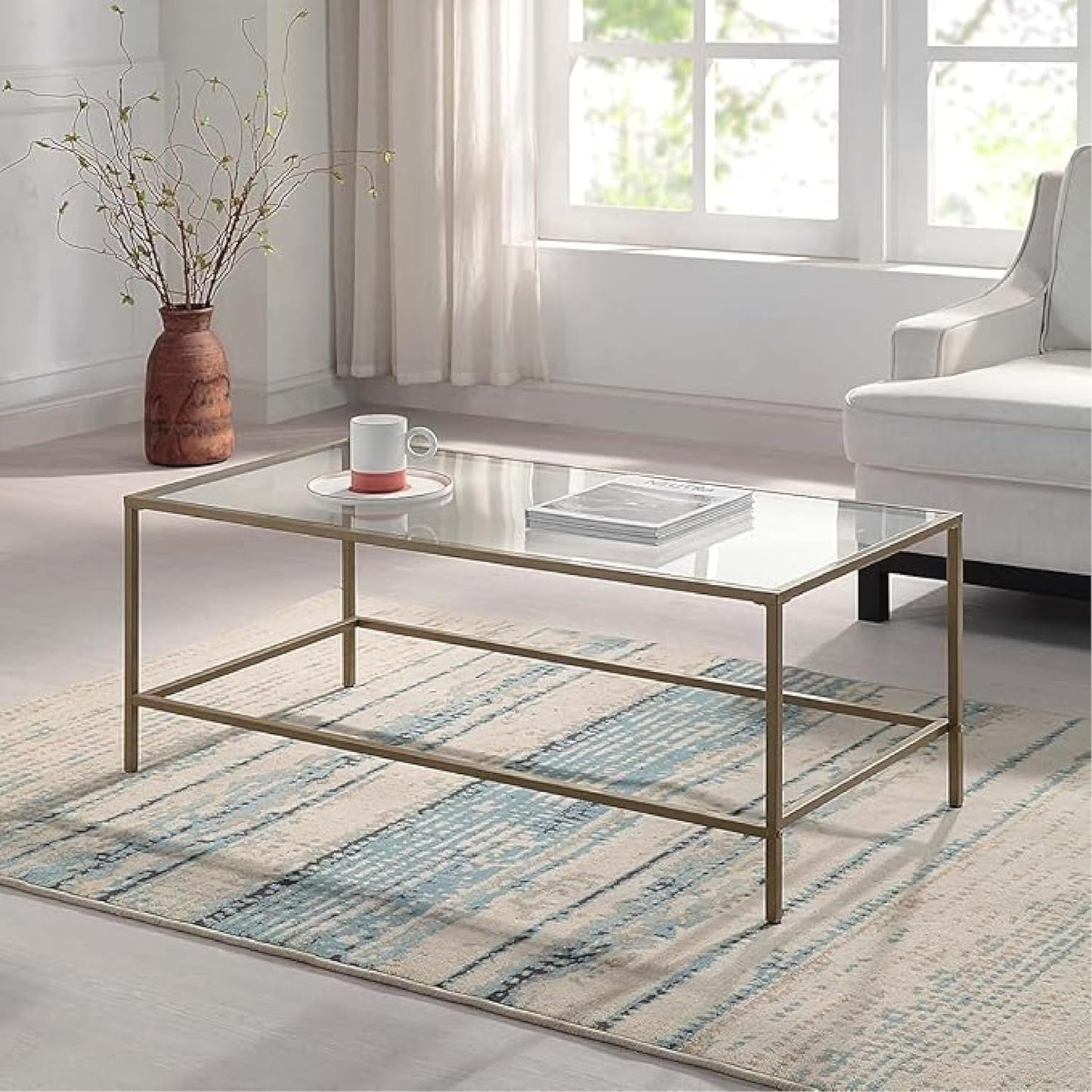 Mesa de centro rectangular, con vidrio temperado y marco de metal dorado. 111cms x 52.7cms x 45.4cms